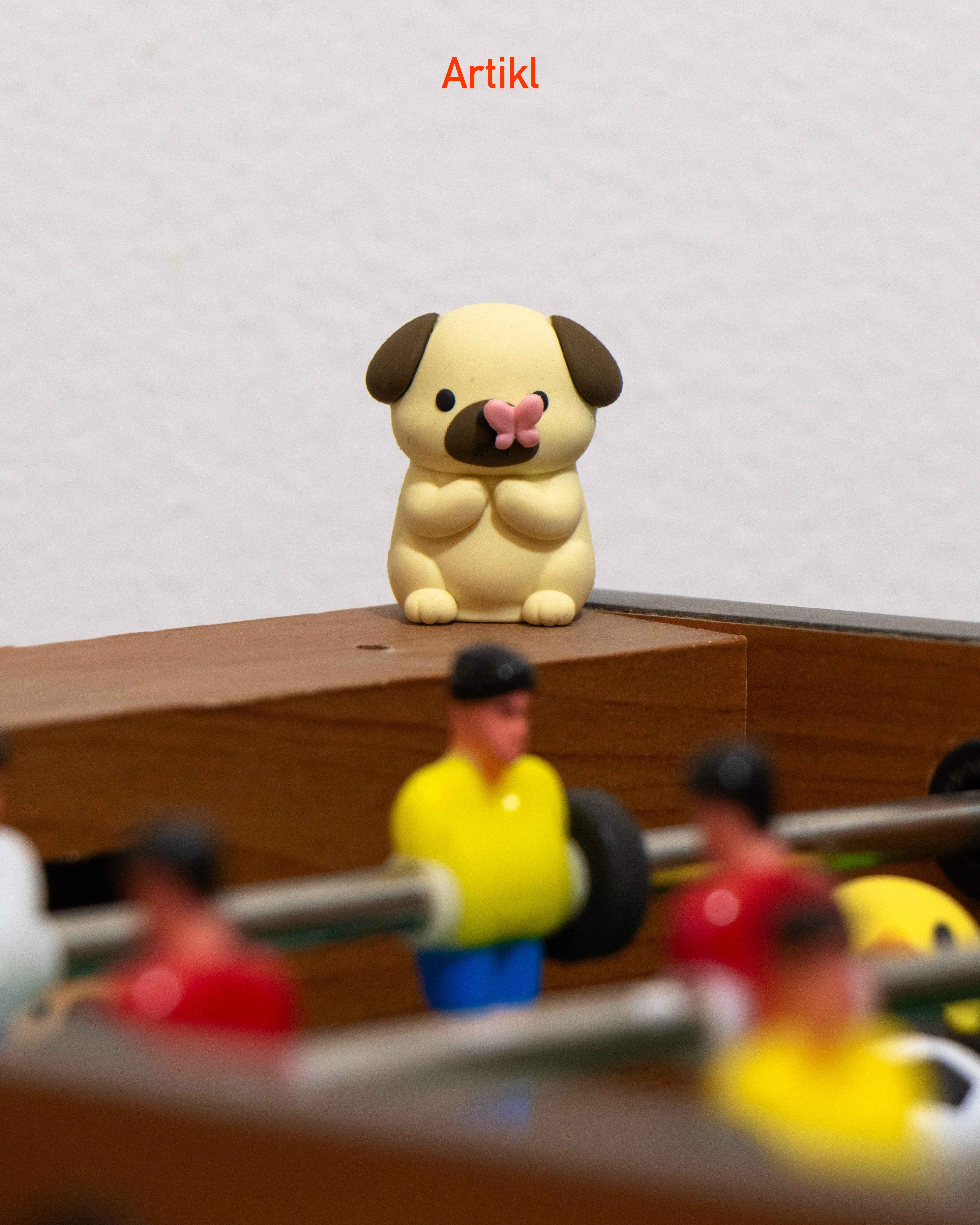 Peek-a-Pals butterfly puppy collectible figure displayed on foosball table as a cute desk companion and decorative accessory