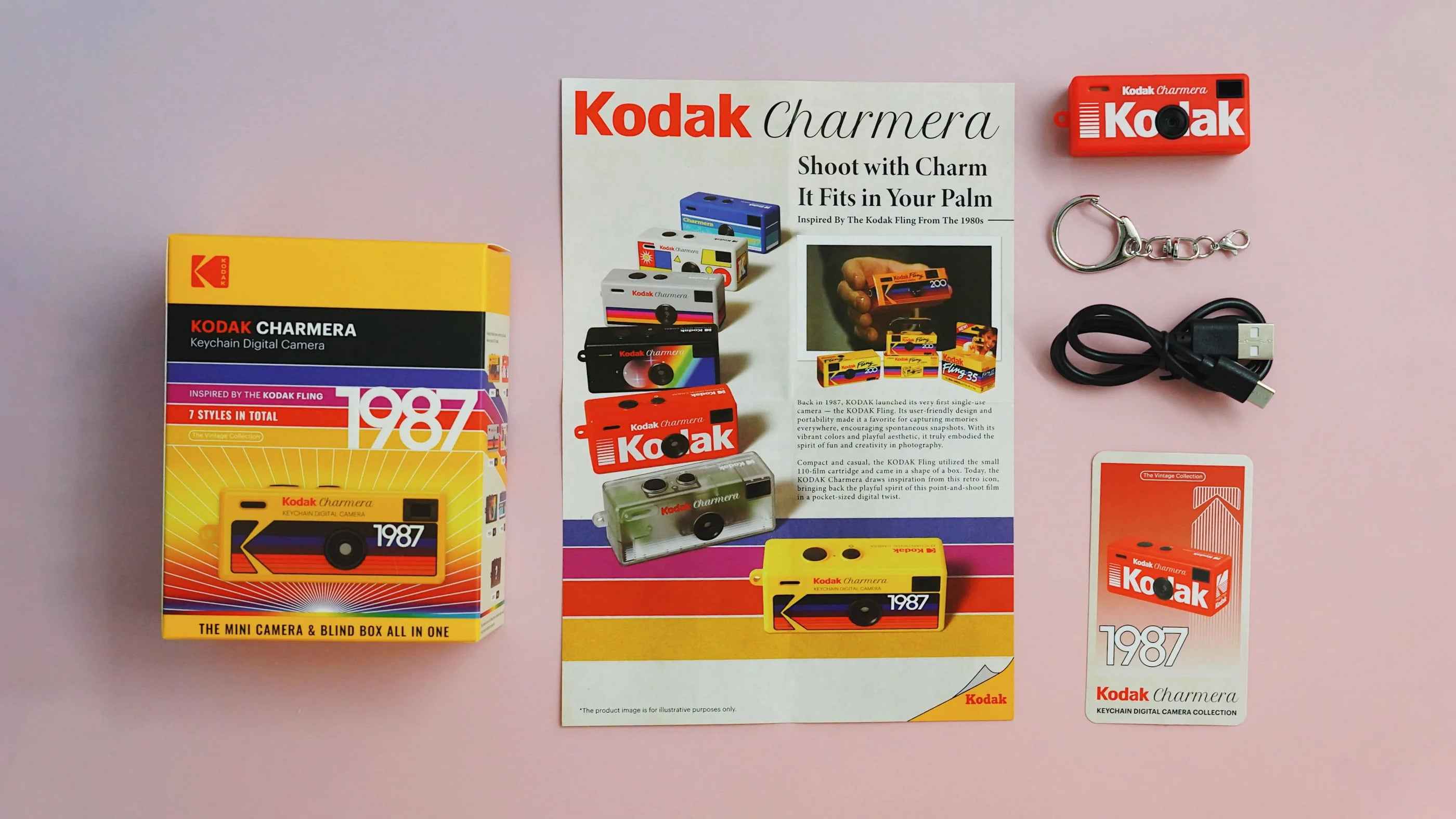 Kodak Charmera keychain digital camera package contents featuring camera, blind box packaging, USB-C charging cable, keychain, collector card, and product guide