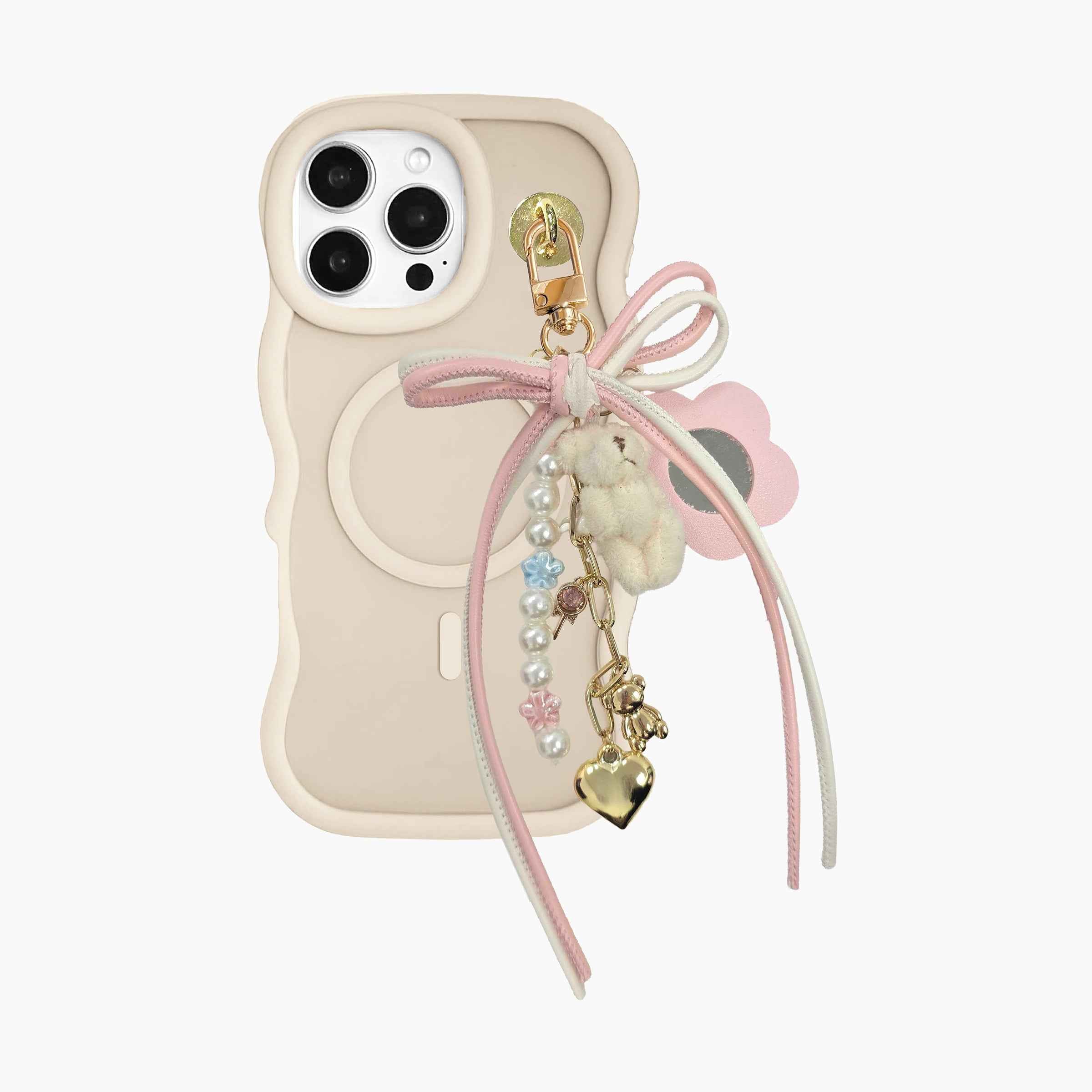 Pink bow phone charm attached to MagSafe phone case featuring pearl beads, plush bunny charm, flower accent, gold heart pendant, and decorative ribbon details