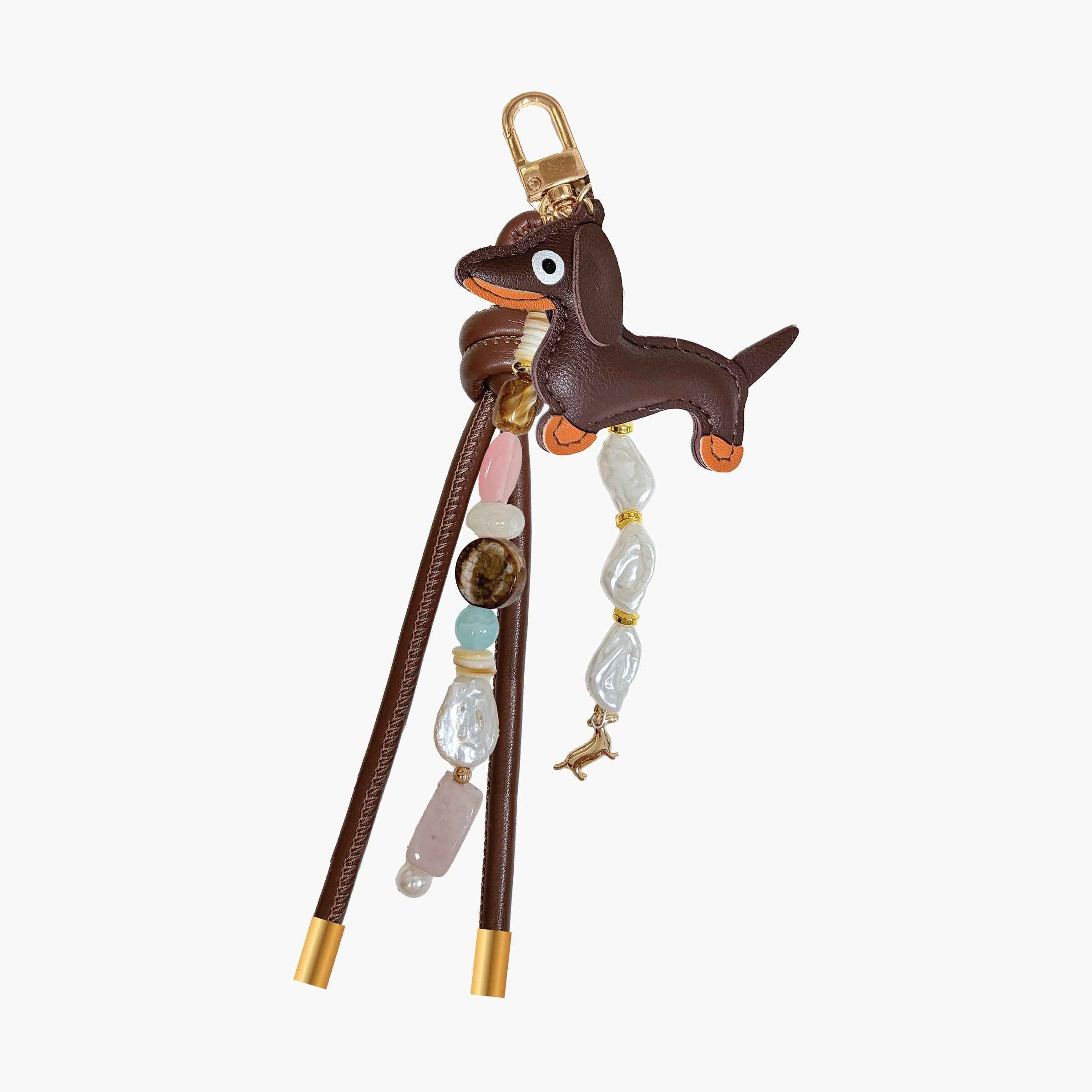 Dachshund-inspired bag charm featuring leather dog pendant, gemstone-style beads, pearl accents, and decorative tassel details