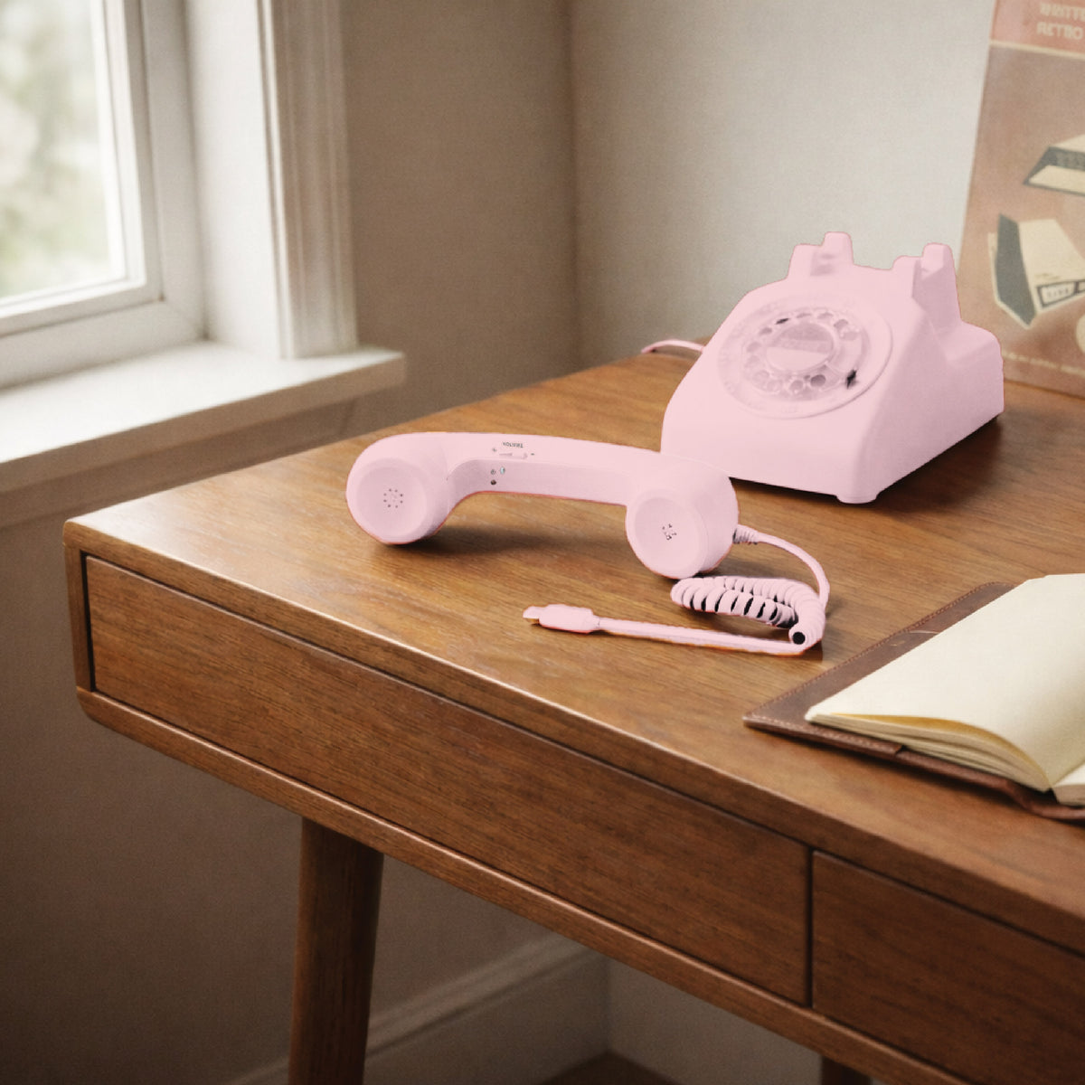 Pink USB-C retro phone handset beside a pink rotary phone on a wooden desk, highlighting a cute retro desk accessory and giftable decor