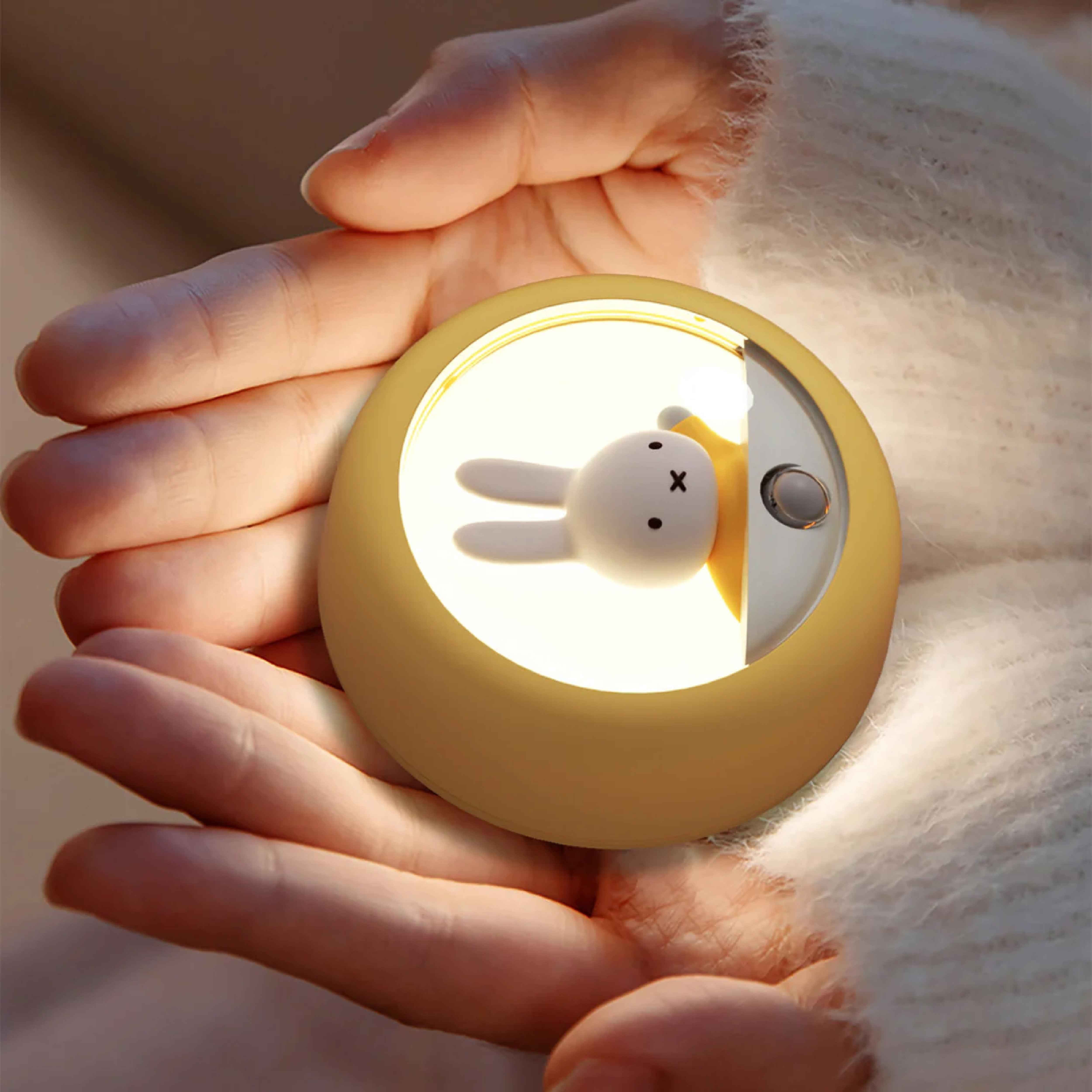 Portable Miffy LED night light held in hand, featuring a collectible Miffy figure, warm ambient lighting, and compact design for bedrooms, nurseries, and travel