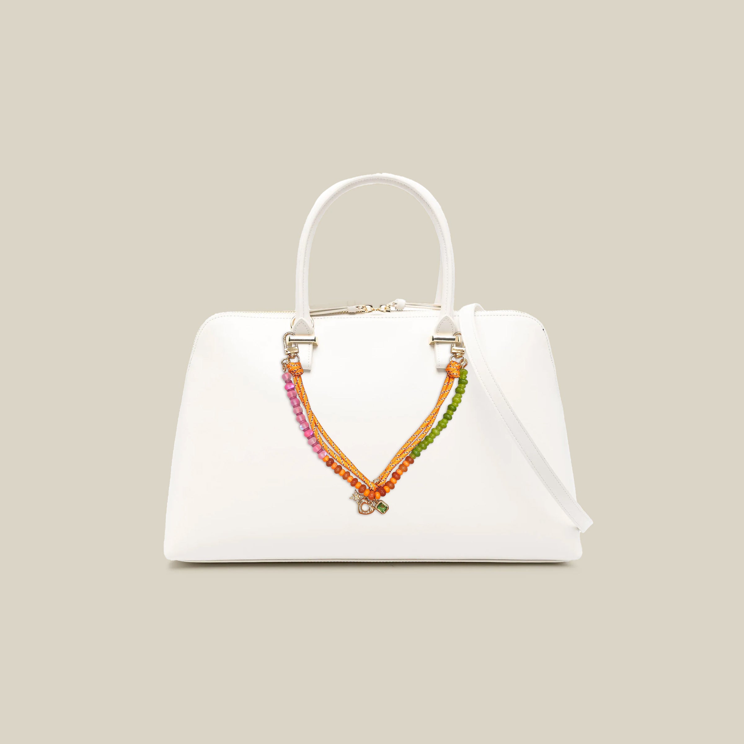 Colorful beaded handbag charm featuring gemstone-style beads, braided rope details, and decorative accents attached to a white handbag