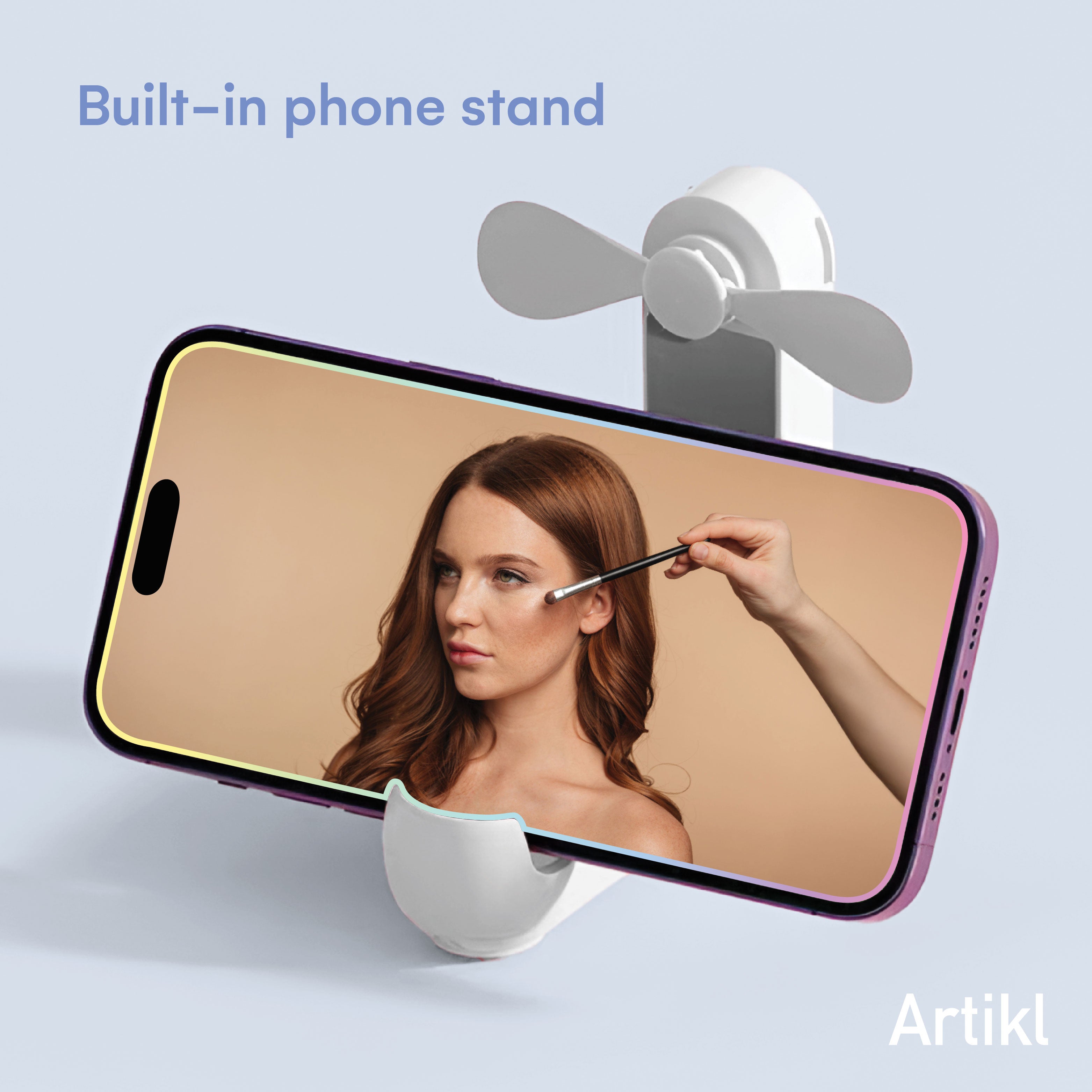 Foldable Handheld Fan with built-in phone stand holding a phone at an angle for hands-free makeup application