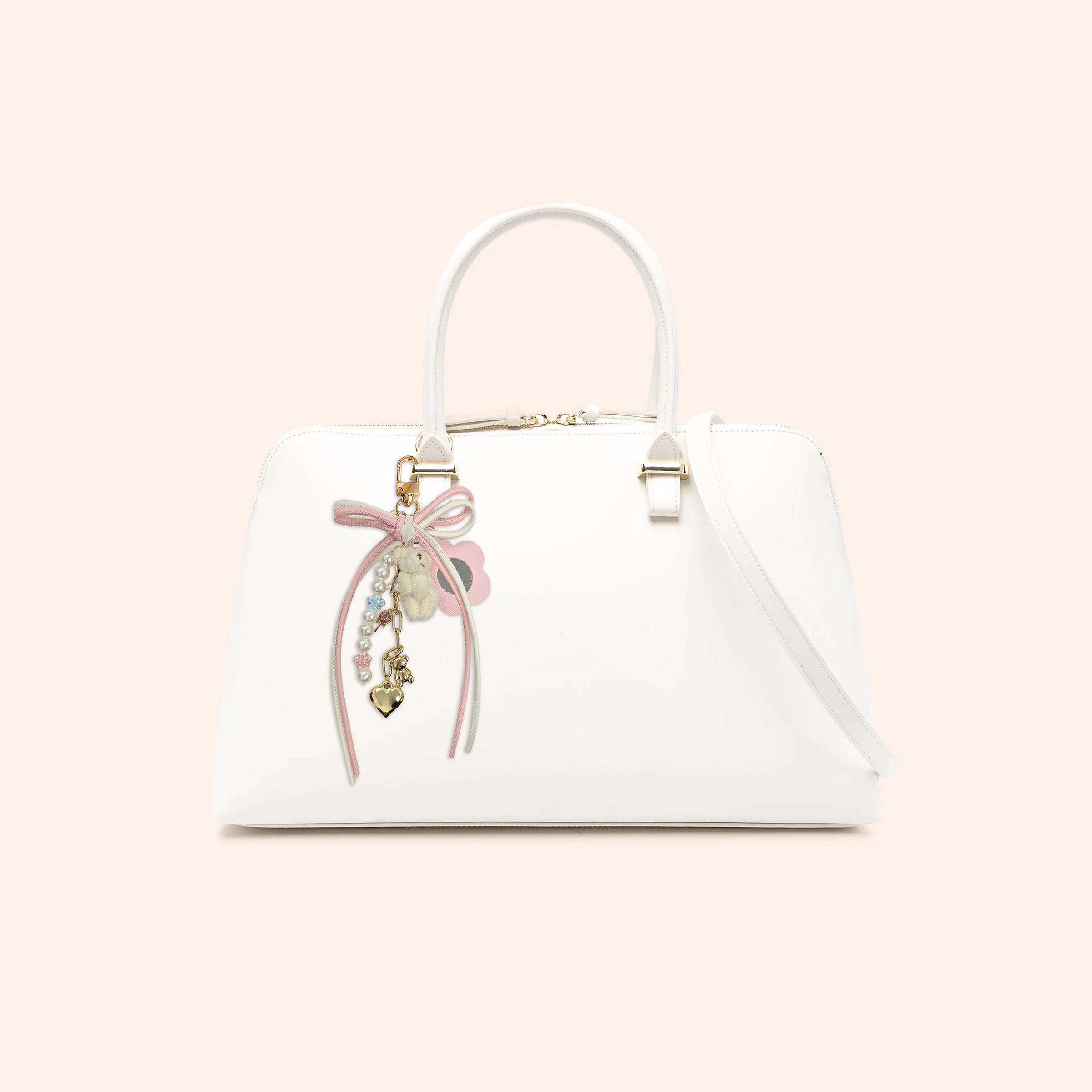 White handbag with decorative bow and Pink Coquette Teddy Phone Charm on a light pink background